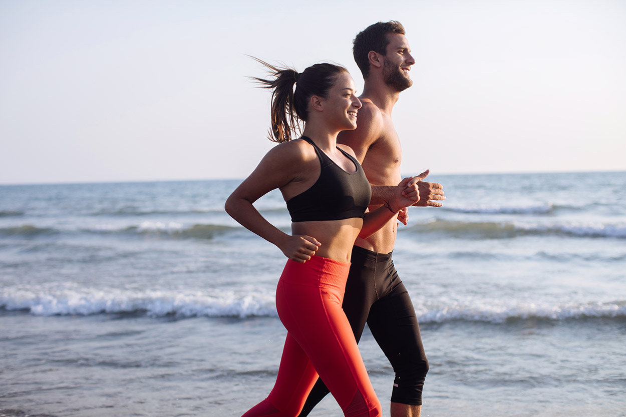 Couple Running Towards Sunset