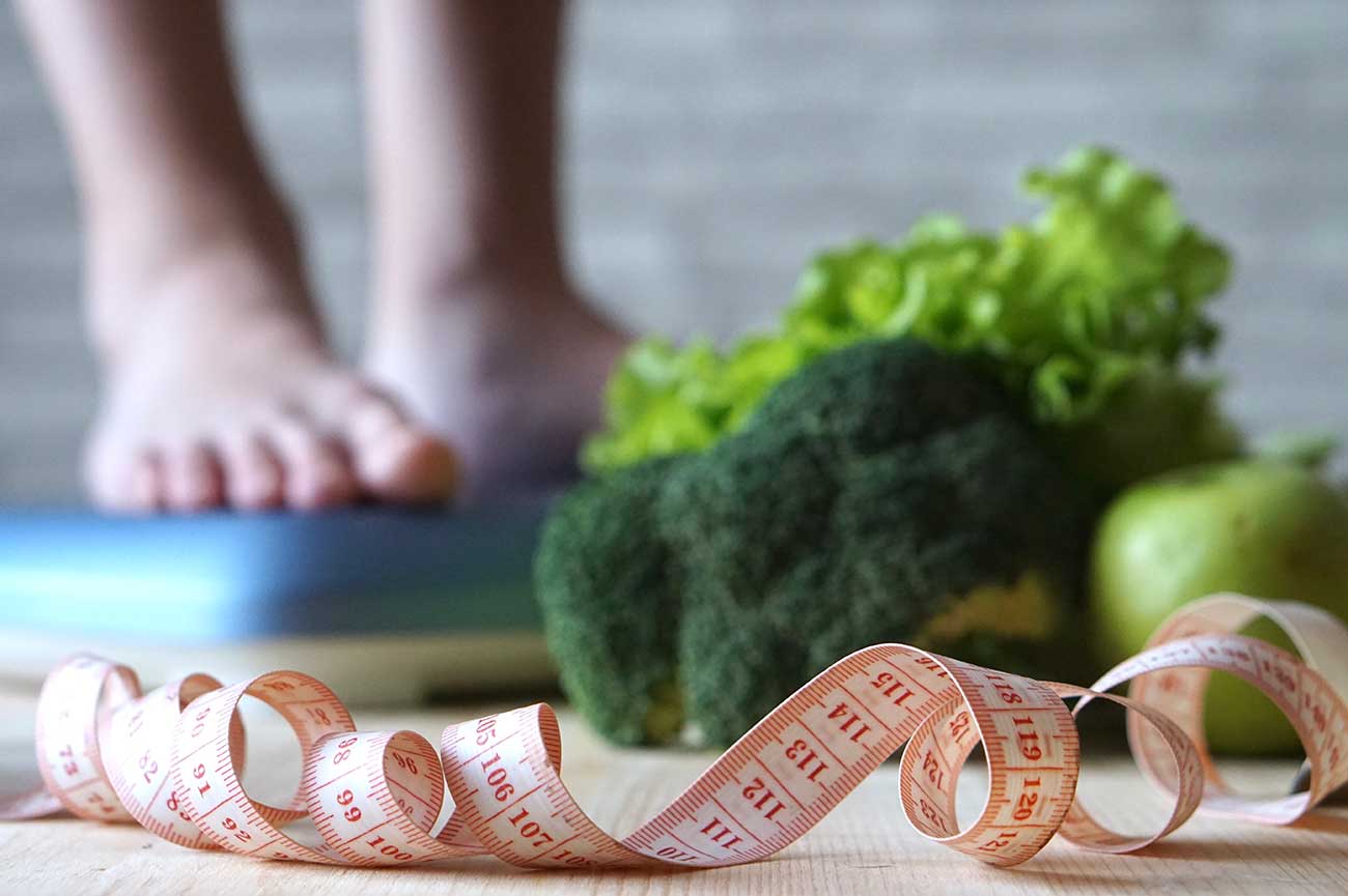 Man Standing on Weight Scale.