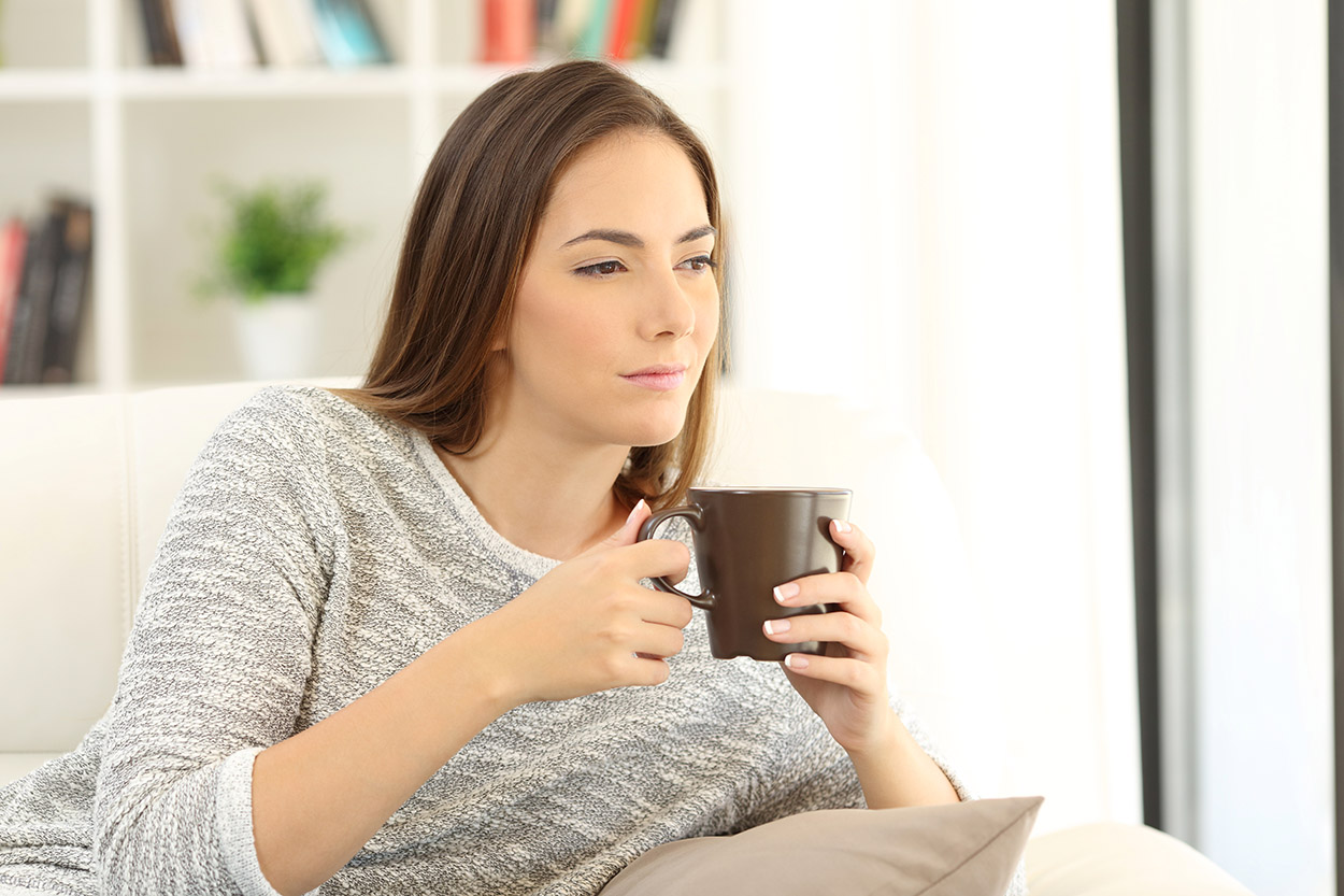 Woman sitting on couch wondering